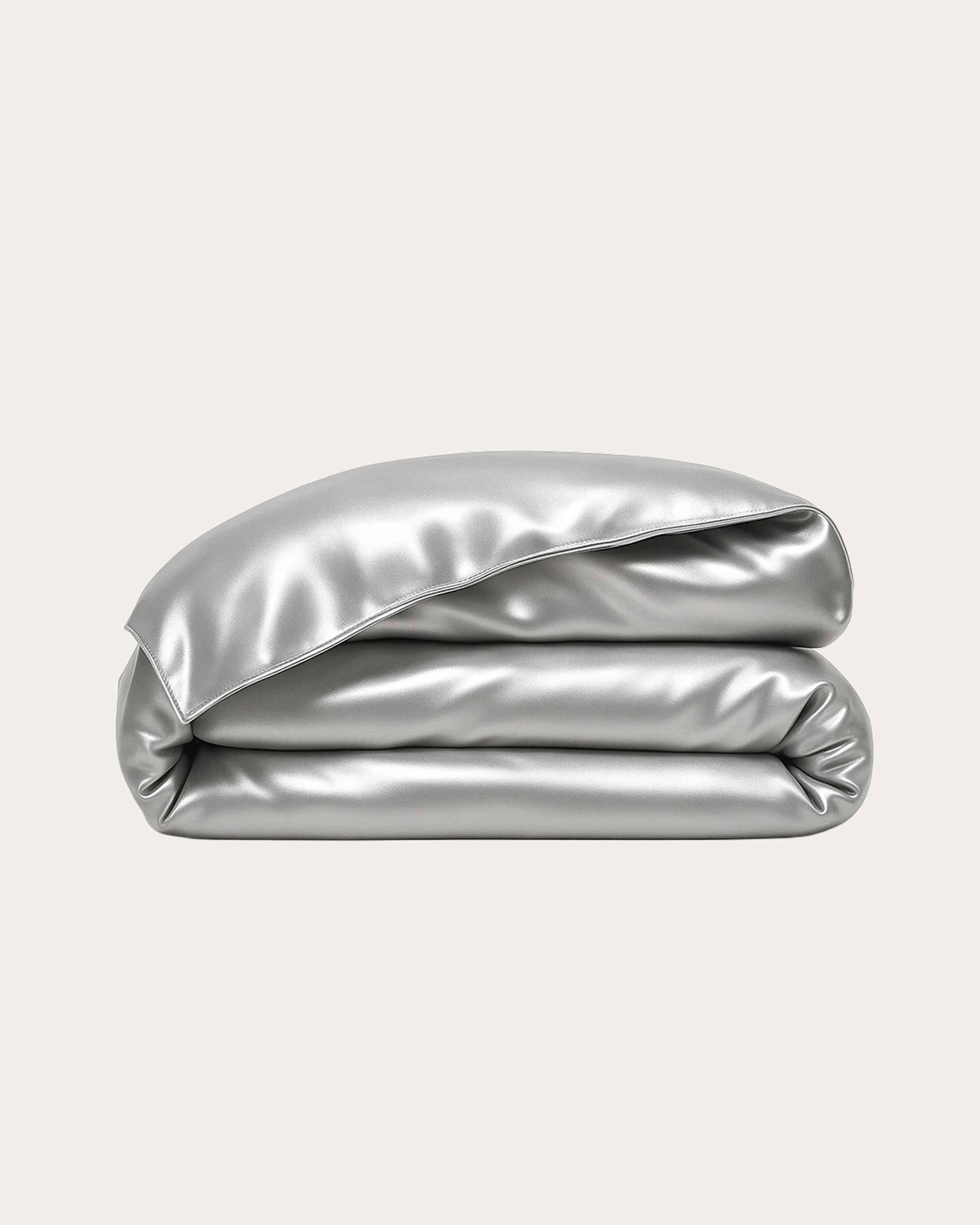 Moonlight Silver Satin Duvet Cover neatly folded, showcasing its soft, silky texture and modern metallic sheen.
