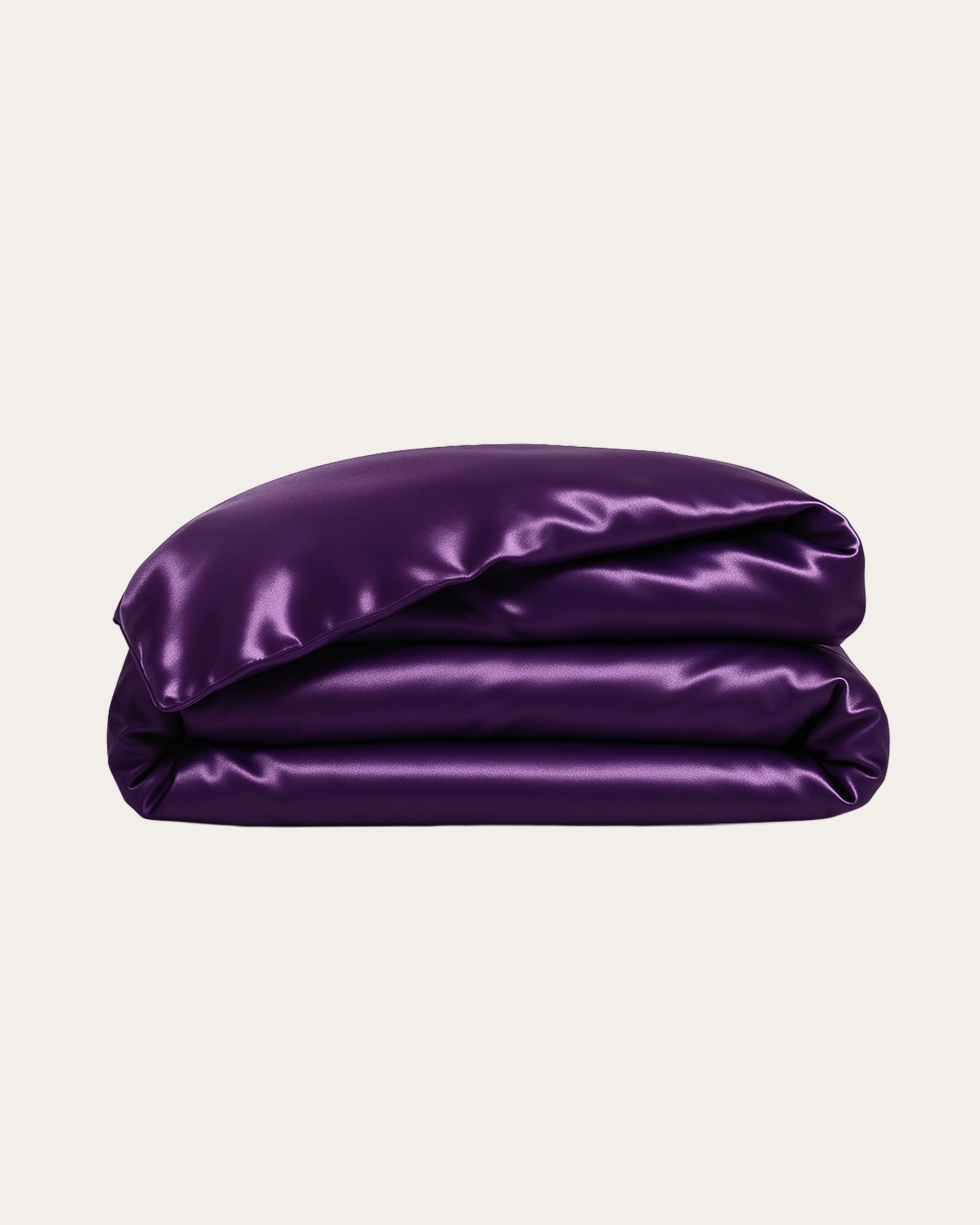 Deep purple satin duvet cover stacked, showcasing its luxurious sheen and smooth texture.